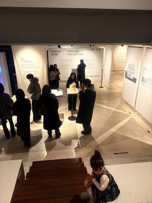 보텍스 갤러리에서 전시 패널을 둘러보는 관람객들